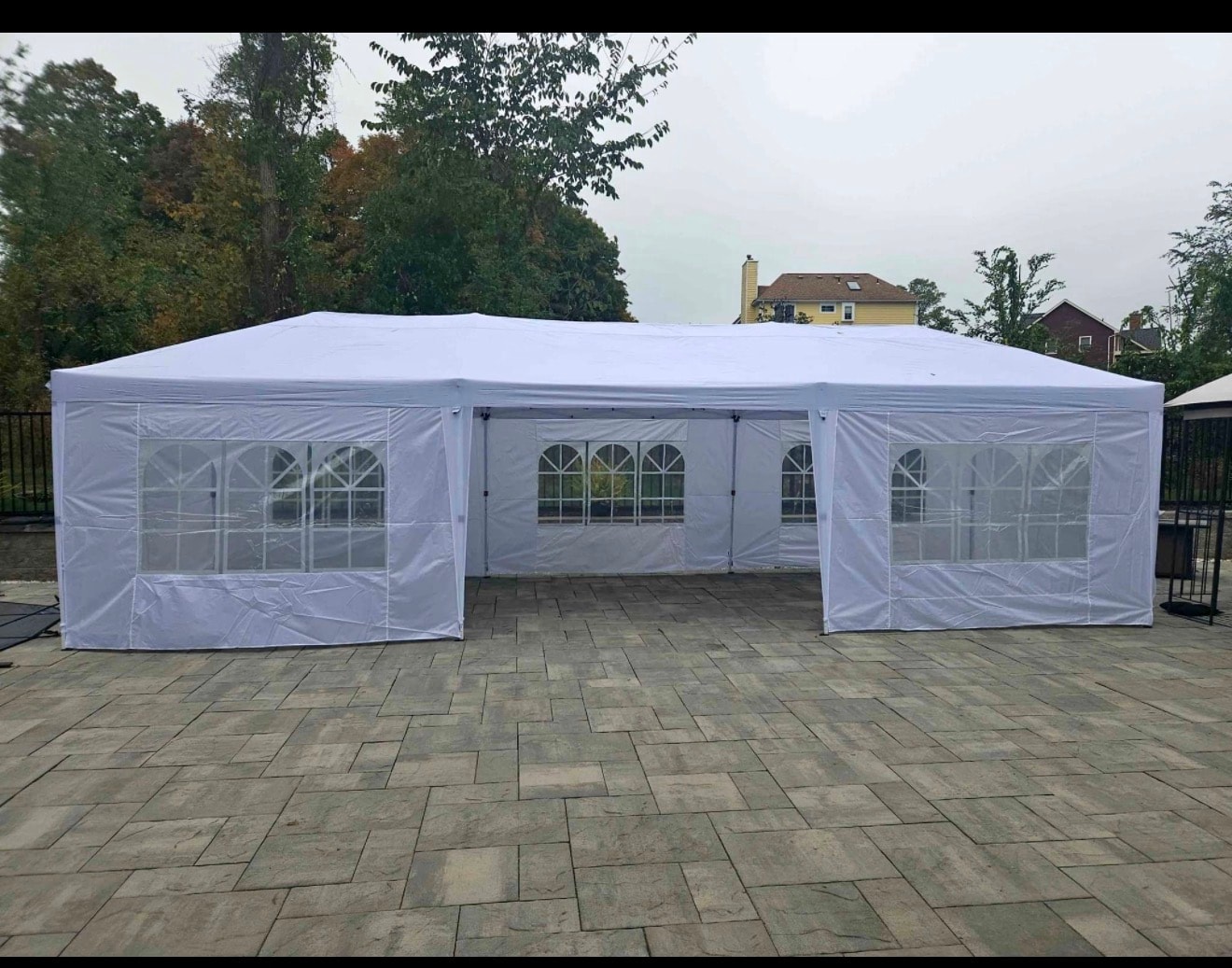 10x30 white party tent with side walls, windows and doors set up outdoors